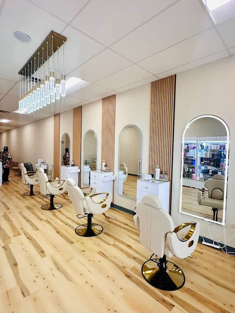Cream salon chairs and illuminated mirrors inside Ima's Threading and Spa